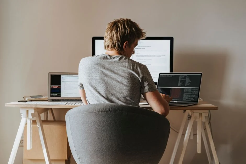 Un espace de travail contemporain avec deux écrans d’ordinateur affichant des projets de web design, mettant l’accent sur la technologie et la productivité.